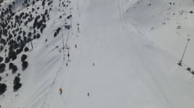 Türkiye 'nin ünlü kayak merkezi Erzinca' nın insansız hava aracı görüntüsü, insanlar karlı dağ yamacında kayak pistinde eğleniyor, tatilciler kayak yaparak zaman harcıyor.