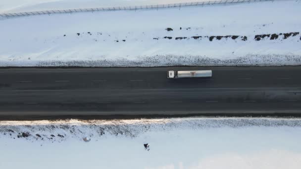 货运卡车在雪地公路上的空中通过 在雪地通道上的货物运输 冬季通过主要公路的货运卡车的运输 — 图库视频影像