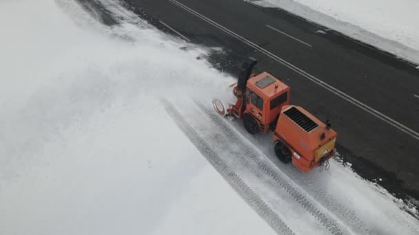 雪に覆われた道路をクリアするために働くピックアップトラックタイプのプロウの空中ドローンビュー 輸送雪の高速道路上で実行されている吹雪 — ストック動画