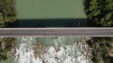 Nehir Üzerindeki Köprü, geniş ovadaki nehrin akarsu yolunun drone görüntüsü, nehir kenarındaki yeşil tarım arazisi habitatı.