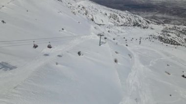 Kışın dağ yamacına kurulan teleferik hattının görüntüsü, tatilcileri yüksek dağlara götüren halat demiryolu, kış tatilcileri için hava yolu sistemi.