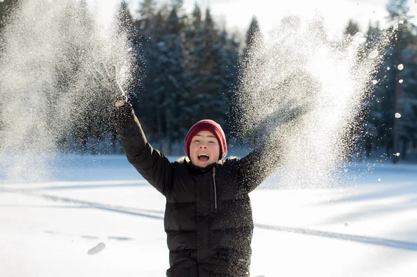 Хлопчик-підліток грає зі снігом у лісі в сонячний зимовий день. Щасливі зимові ігри та здоровий спосіб життя . — стокове фото