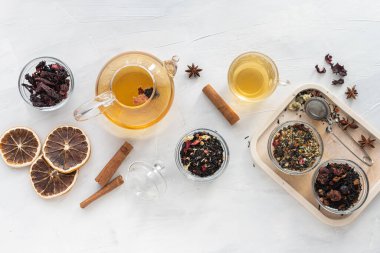 Cam bir çanakta farklı çeşitte Çin bitkisi ve yeşil çay seti ve yeşil arka planda sıcak çay. Yukarıdan bak. Mesaj için yer var. Bitkisel tedavi. Sağlıklı yaşam tarzı.