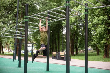Spor giyimli genç bir çocuk dışarıda antrenman yapıyor. Genç bir adam bir yaz parkında el gezdirici ile dolaşıyor. Gençlerin hobileri. Sağlıklı yaşam tarzı.
