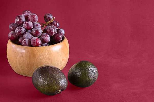 Black grapes and avocados from the garden, fresh seasonal fruit.