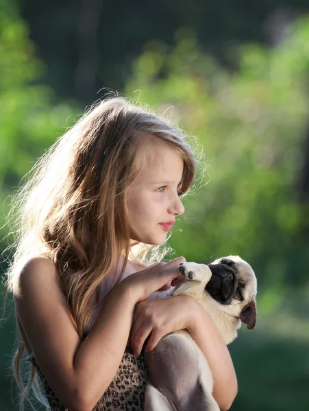 Happy child holding a small dog — Stock Photo, Image