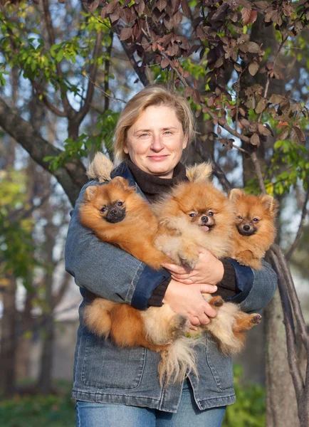 Smiling blonde woman middle aged with her dogs and enjoying outd Stock Photo