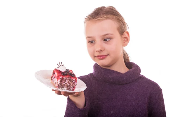 Pretty young girl looking at cake on white background — Stock Photo, Image