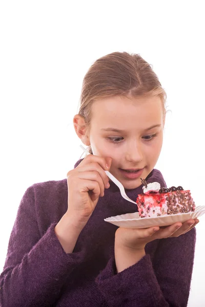 Pretty young girl looking at cake on white background — Stock Photo, Image