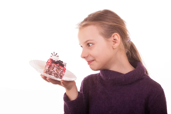 Pretty young girl looking at cake on white background — Stock Photo, Image