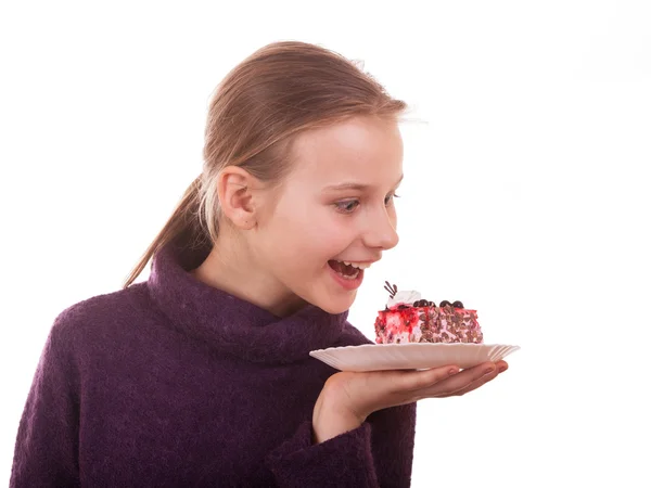 Pretty young girl looking at cake on white background — Stock Photo, Image