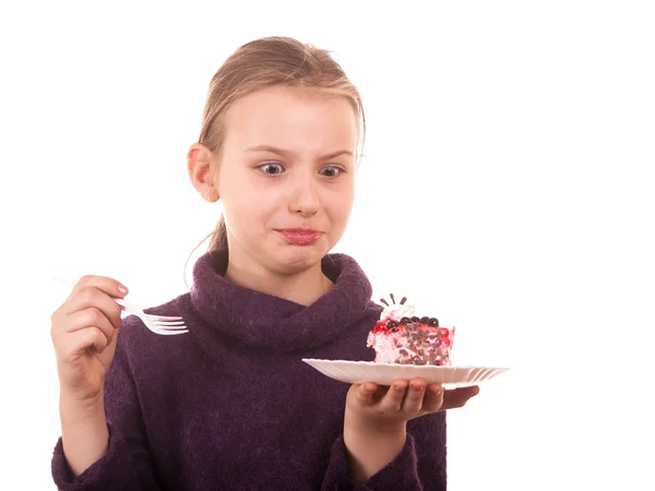 Pretty young girl looking at cake on white background — Stock Photo, Image