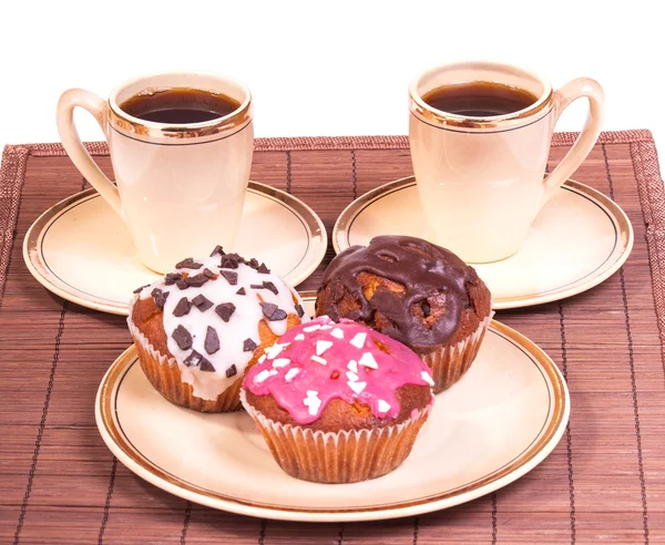 Tassen Kaffee und Muffins auf einem Teller — Stockfoto