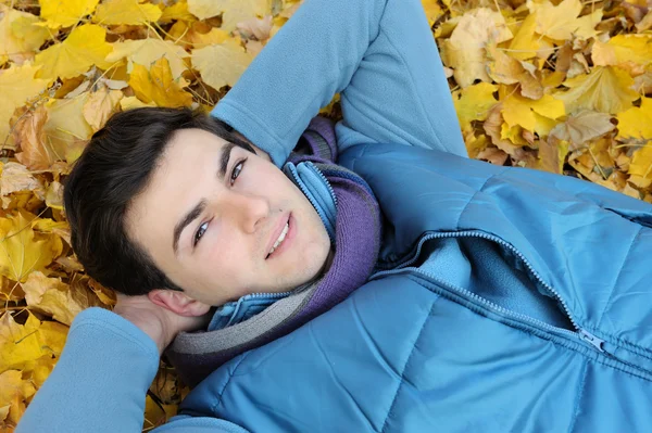 Junger Mann sitzt im Park. — Stockfoto