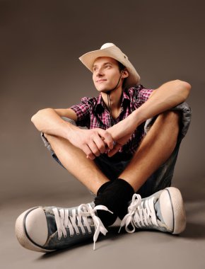 spor ayakkabı, şapka oturan adam