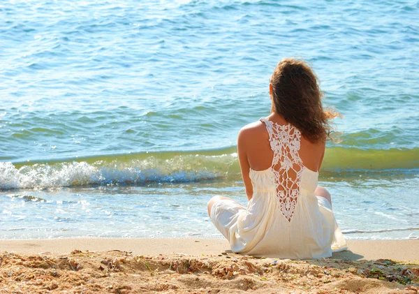 Chica joven en un vestido blanco en la playa — Foto de Stock