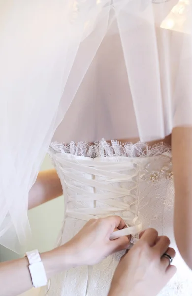 Hände, die der Braut ein Korsett anziehen — Stockfoto