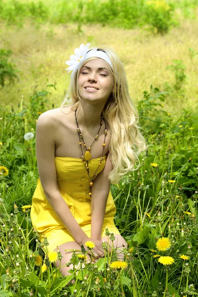 Girl sitting in field with camomiles. — Stock Photo, Image