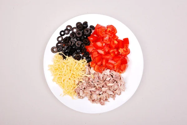 Olijven, kaas, vlees en tomaat op een plaat — Stockfoto