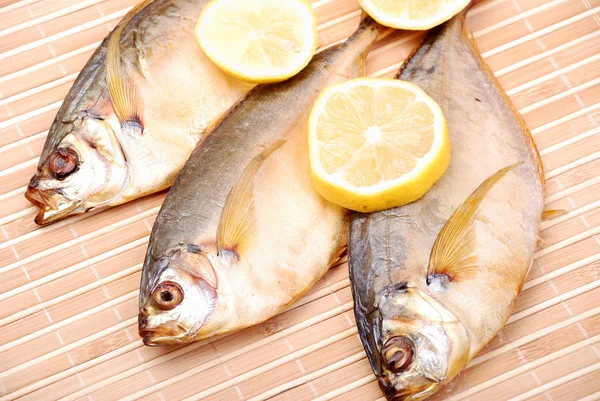 Smoked fish with a lemon — Stock Photo, Image