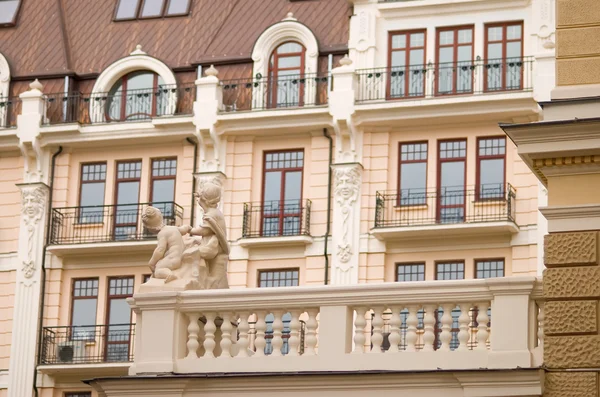 Building in historical style with statue in the foreground — Stock Photo, Image