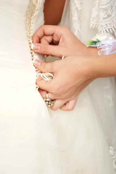 Hands tightening a corset to the bride — Stock Photo, Image