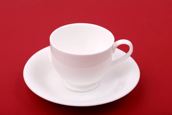 White porcelain cup on a red — Stock Photo, Image