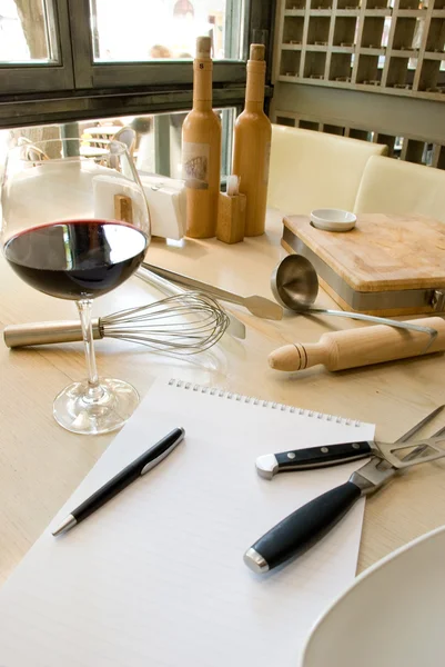 Ustensiles, cahier et verre de vin — Photo