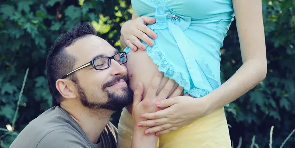 Futuro pai ouvindo a barriga de sua esposa grávida . — Fotografia de Stock