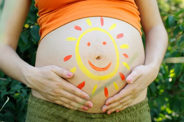 Kobieta w ciąży brzuch z rysunek słońce. — Zdjęcie stockowe