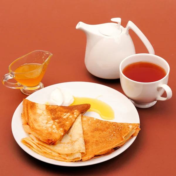 Pancakes with honey and tea. — Stock Photo, Image