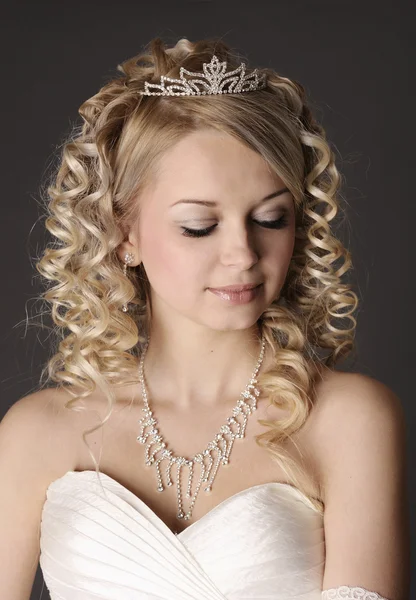 Young woman dressed as a bride on a gray. — Stock Photo, Image