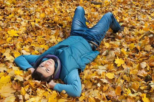 Junger Mann liegt im Laub. — Stockfoto