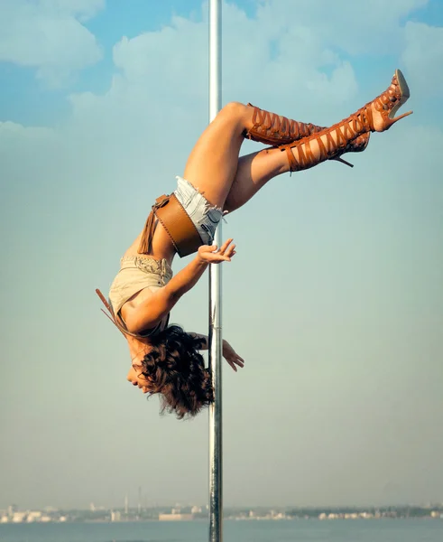 Nő gyakorlása pole dance szabadban. — Stock Fotó