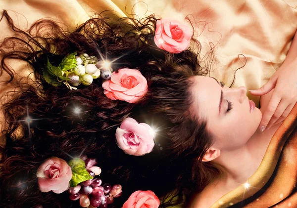 Девушка с длинными здоровыми волосами украшена цветами . — стоковое фото