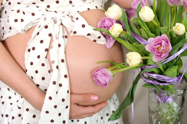 Gravid kvinna buken med blommor. — Stockfoto