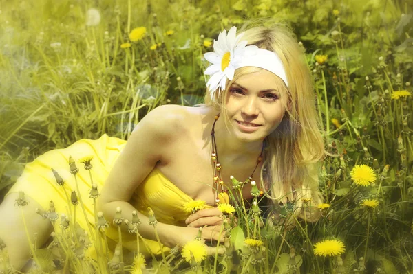 Jong meisje in gele jurk in veld met camomiles. — Stockfoto