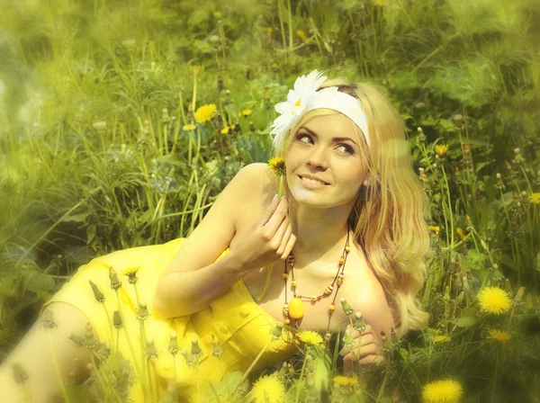 Menina em vestido amarelo no campo com camomilas . — Fotografia de Stock