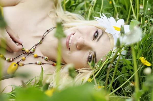 Šťastná žena leží v oblasti s camomiles. — Stock fotografie