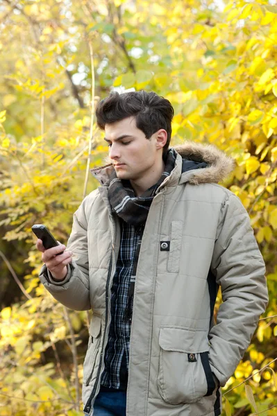 Sonbahar Parkında Eski Tarz Telefonuyla Çekici Bir Genç Adam — Stok fotoğraf