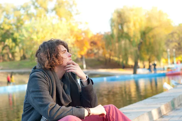 秋天公园里 坐在城市湖畔的少年男子肖像 — 图库照片