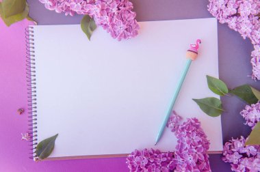 Boş uzay not defteri listesi, leylak demeti, çiçek ve kalem, bahar pankartı ahşap bir zemin üzerinde, düz bir üst görünüm, yatay görünüm