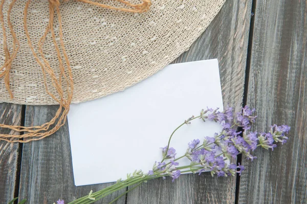 Ahşap zemin üzerinde lavanta çiçekleri ve güneş şapkası olan boş uzay beyaz listesi, üst görünüm, yatay