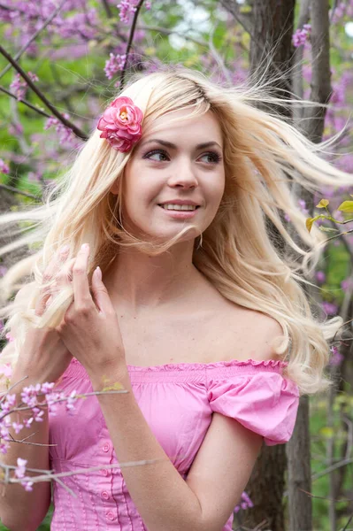 Glimlachende Jonge Vrouw Met Blond Haar Poseren Bloeiende Lentetuin Winderig — Stockfoto