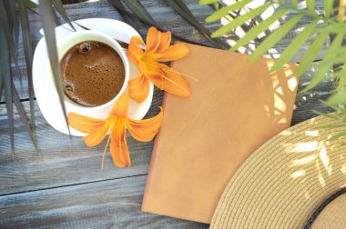 Sabah kahveyle, şapkayla ve defterle ahşap bir masanın üzerinde düzleşir.