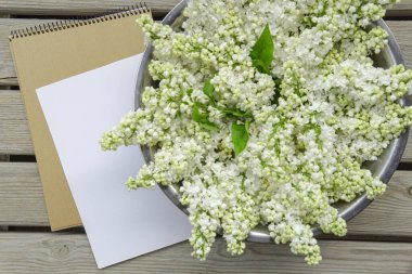 Kapalı beyaz leylak çiçekli beyaz kağıt kart ve ahşap zemin