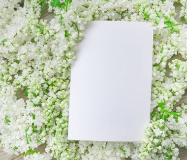 Kapalı beyaz leylak çiçekli beyaz kağıt kart ve ahşap zemin