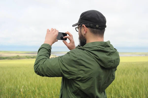 大人の観光客の男は野外でスマートフォンの屋外で写真を撮る — ストック写真