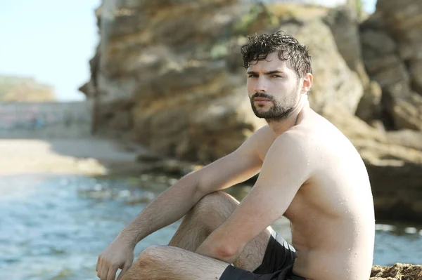 Jovem Cansado Sentado Perto Oceano Olhando Para Câmera — Fotografia de Stock