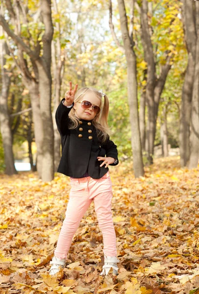 Little Blonde Girl Posing Showing Victory Autumn Park Happy Childhood — Stockfoto